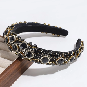 Close-up of luxury black headband with sparkling crystals on a wooden display stand