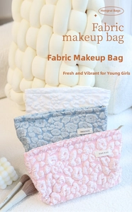 Detailed texture of cloud-pattern embossed cosmetic bags in pink blue and white