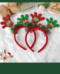 Detailed view of red velvet Christmas headbands with glittery Merry Christmas gloves