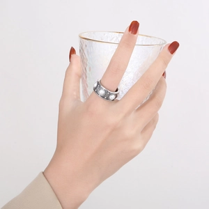 Bague rétro en acier inoxydable avec trois perles sur main tenant un verre doré