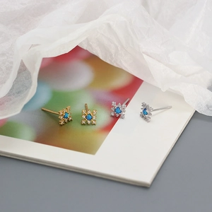 Detail showing snowflake earrings in gold and silver finish with blue opal and tiny crystals