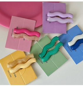 Detail of colorful wavy resin hair clips with marble texture on handmade display cards