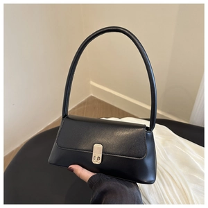 Detailed view of the silver metal clasp and smooth black PU leather texture on the bag