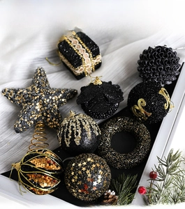 Detailed flat lay of black and gold Christmas ball ornaments and a tree topper star