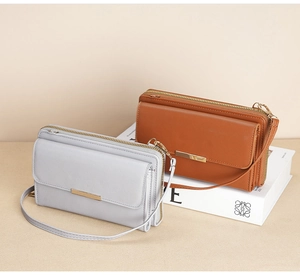 Close-up of minimalist women's crossbody wallet with elegant gold metal bar and thin strap