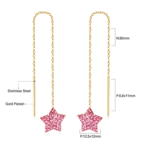Macro shot of gold plated stainless steel star drop earring with pink crystal details