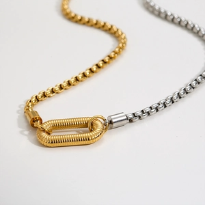 Close-up of dual-tone box chain necklace with spiral textured gold oval connector clasp