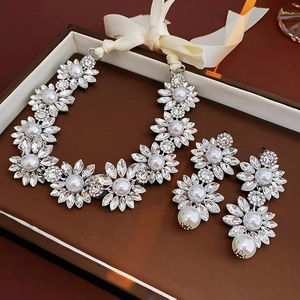 Detailed view of silver flower jewelry set with rhinestones and pearls in a gift box
