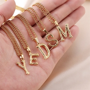 Golden alphabet necklace pendants with organic bark texture in Y E D S M styles