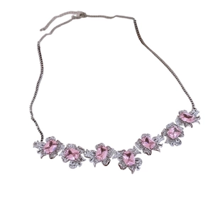 Exquisite silver necklace with pink oval gemstone and floral zircon accents on white background
