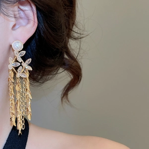 Detail of 18K gold plated flower fringe earrings with pearls on model in profile