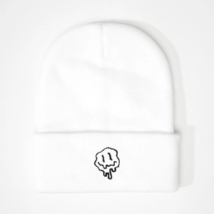 White knitted beanie featuring a black melting smiley face embroidery in streetwear style