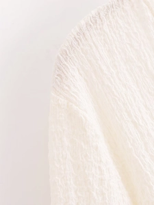 Macro shot of white textured cotton fabric detail for a loose summer vacation set