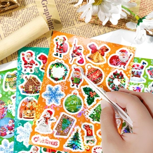 Close-up showing tweezers picking up a laser-finish Christmas sticker for gift DIY