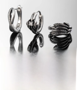 Detailed view of silver titanium steel earrings set with feather design and cubic zirconia