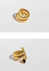 Detailed view of gold multi-layer snake ring with textured surface and black zircon droplet