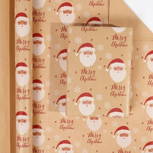 Detail of kraft Christmas wrapping paper roll with festive Santa and snowflake patterns