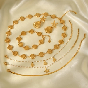 Détail de l'ensemble de bijoux en plaqué or 18k avec coquillages et étoiles de mer