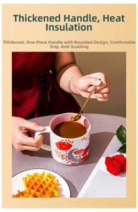 Detail of hand-painted floral ceramic mug with thick C-handle and pink interior lining