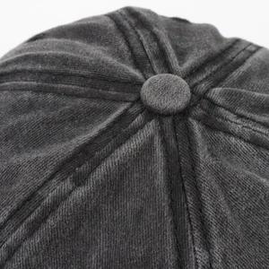 Macro shot of dark grey baseball cap top showing washed fabric texture and stitching