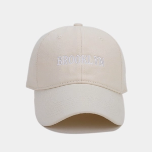 Detail of Brooklyn embroidery on beige cotton canvas baseball cap with curved brim