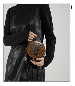 Detail of round brown punk handbag with 3D crystal skull and metal rivets