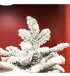 Detailed close-up of artificial pine needles covered in fake snow for tabletop Christmas tree