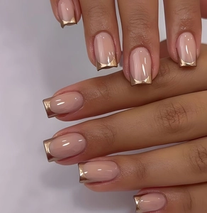 Macro view of medium square press-on nails with nude base and rose gold metallic French tips