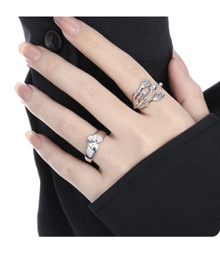 Detailed view of silver heart ring and wrap-around ring with crystals on hand