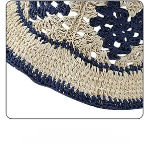 Détail d'un chapeau de paille tissé main montrant la texture crochet beige et marine