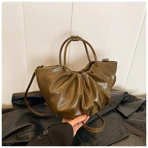 Detailed view of the olive green pleated cloud bag in premium glossy leather finish
