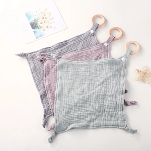 Tres mantitas de seguridad de muselina con aros de madera en gris, rosa y verde
