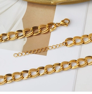 Dettaglio macro di catena a doppia maglia placcata oro 18K con texture e chiusura a moschettone