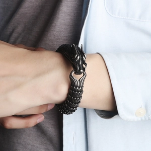 Detail of dragon scale pattern on gun black stainless steel bracelet worn on wrist