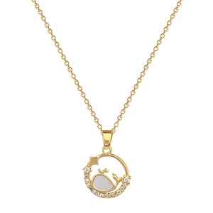 Gold whale shell pendant necklace with sparkling cubic zirconia on a white background
