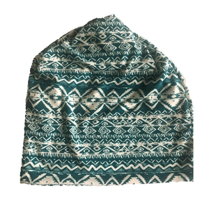 Detail of ethnic geometric pattern fabric on a teal and white bohemian style beanie