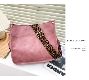 Pink leather tote bag detail with leopard print strap against soft blind shadows