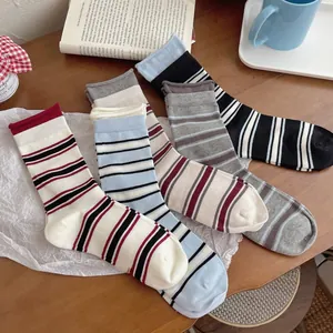 Close-up of colorful striped cotton mid-calf socks displayed on a wooden table surface