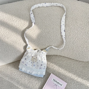 Vue détaillée d'un sac bandoulière blanc avec bordure en dentelle et motifs d'étoiles