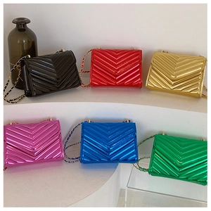 Macro shot of chevron quilted patent leather bags with gold chain straps in multiple colors