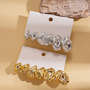 Minimalist liquid metal earrings set in gold and silver finish on white card display