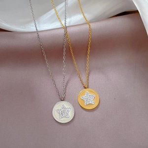 Close-up of gold and silver star pendants with rhinestone centers on silk fabric