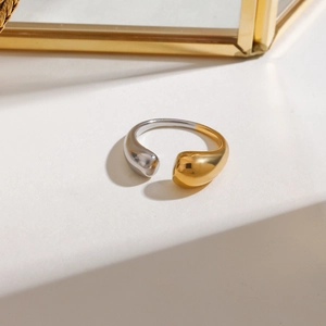 Macro shot of two-tone gold and silver minimalist open ring with sleek teardrop design