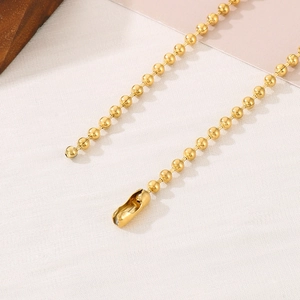 Golden metal bead chain necklace with polished ball links and secure lobster clasp