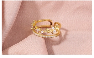 Macro detail of gold plated S925 sterling silver ring with white zircon leaf design