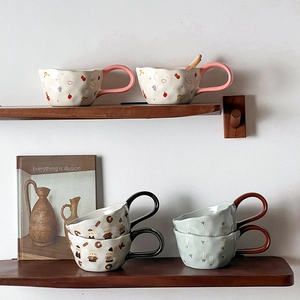Ceramic mugs with cute bear and rabbit patterns displayed on a rustic wooden shelf