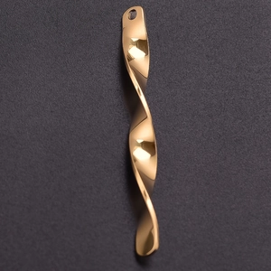 Macro shot of a twisted gold 304 stainless steel long pendant showing a polished finish