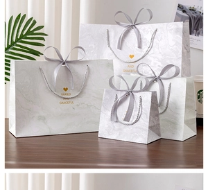 Detailed set of marble pattern gift bags with grey ribbon handles in various sizes