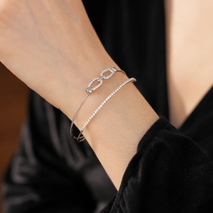 Gros plan de bracelets double couche en argent avec micro-zircons sur un poignet féminin