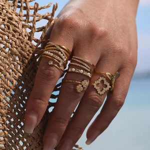 Adjustable gold ring set with pearls and zircon crystals shown in a beach setting